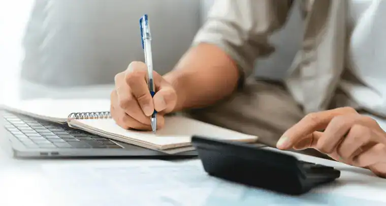 ICT office worker using a calculator and notebook, symbolizing information technology and digital solutions.